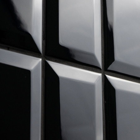 Glänzend schwarze Fliesen reflektieren das Licht und erzeugen einen glänzenden Spiegeleffekt. Sie sind in einem quadratischen Mu