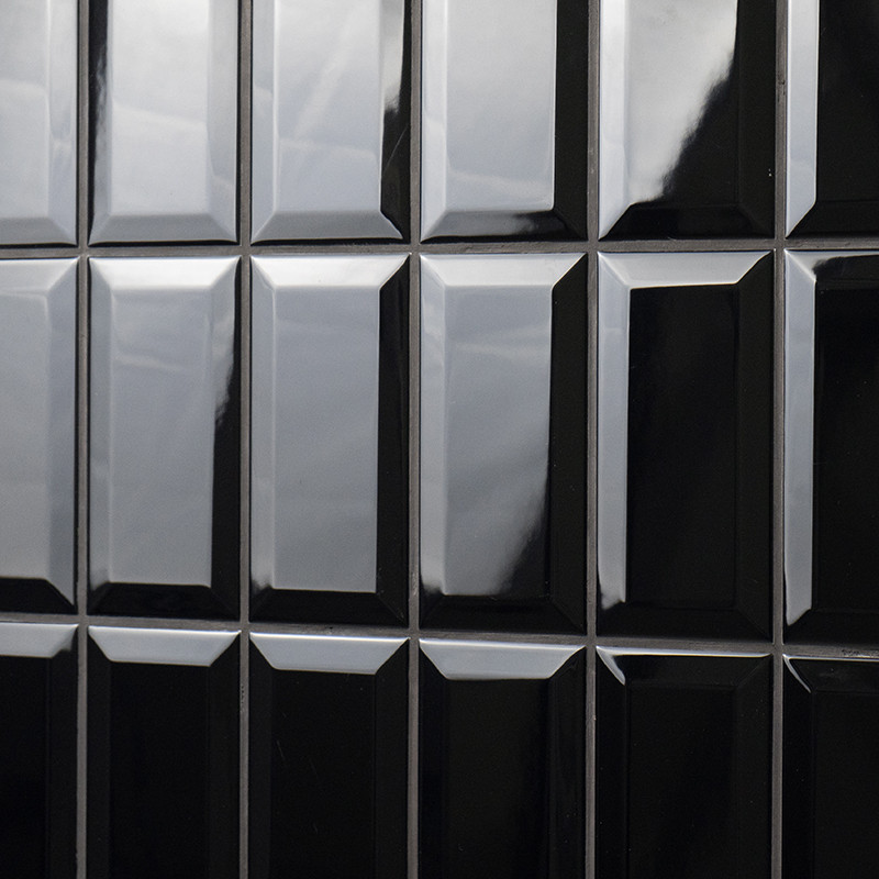 Glanzende zwarte rechthoekige tegels zijn gerangschikt in een rasterpatroon. ze reflecteren licht, waardoor een strakke, moderne