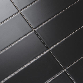 Los azulejos rectangulares negros están alineados diagonalmente en un patrón de cuadrícula, creando una superficie elegante y mo