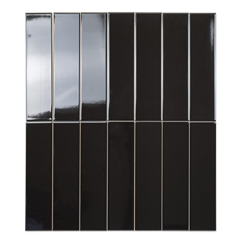 Un carreau noir rectangulaire reflète la lumière, mettant en valeur une finition brillante. Il est isolé sur un fond blanc uni.