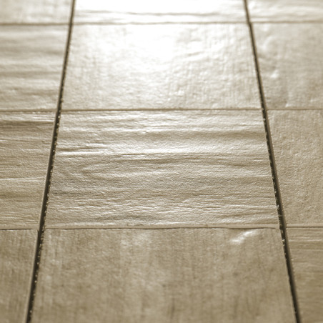 Quadratische beige Fliesen, die in einem Gittermuster angeordnet sind und Licht reflektieren, auf einer ebenen Bodenfläche im In