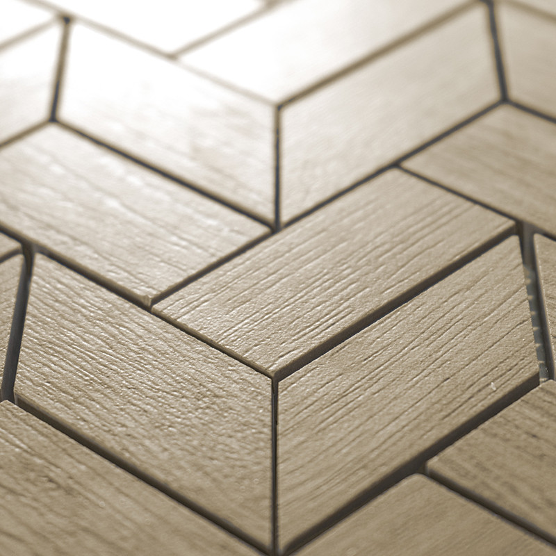 Beige, wood-textured tiles interlock in a chevron pattern, creating a geometric design on a flat surface.