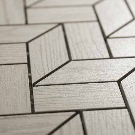 Rechthoekige tegels vormen een zigzagpatroon, dat lijkt op parketvloeren. De lichtgrijze kleur en houtachtige structuur zorgen v