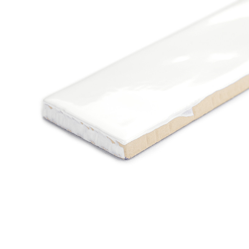 A rectangular tile with a glossy white finish sits upright on a white background, highlighting its smooth surface and beige edge