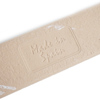 Op een beige kartonnen strook staat de tekst Made in Spain in reliëf, omgeven door een rechthoekige rand, tegen een witte achter