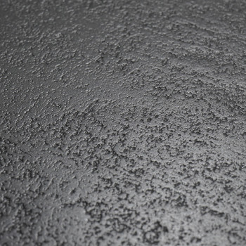 Surface de carrelage noir texturé avec une texture rugueuse et granuleuse, ressemblant à de l'asphalte. La tuile semble être en 