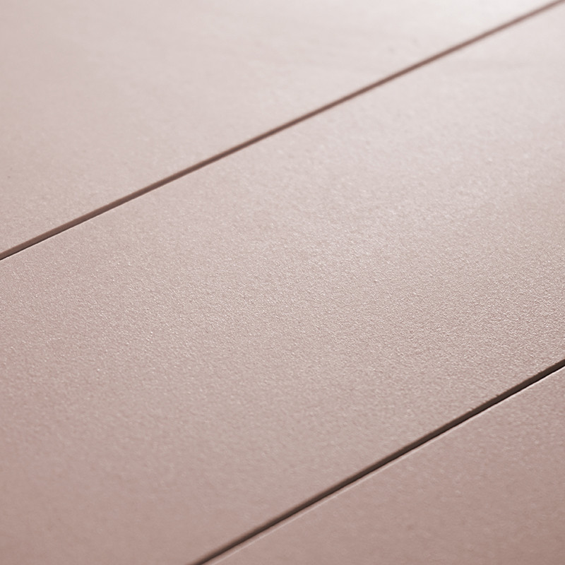 Tres azulejos lisos de color rosa-beige mate se encuentran uno al lado del otro, definidos por líneas de lechada oscuras, creand