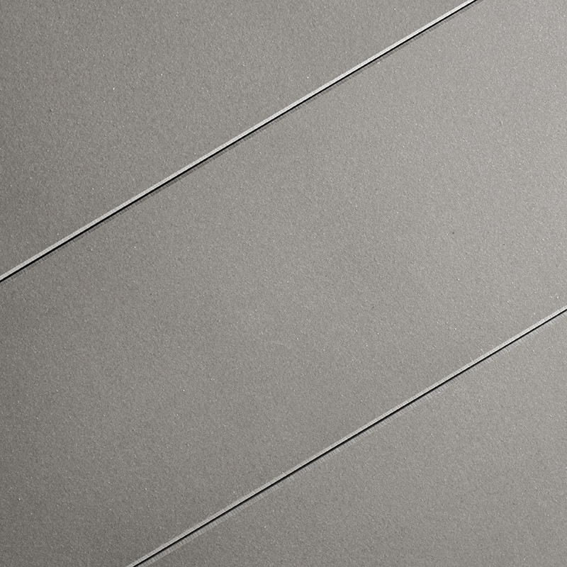 El azulejo gris presenta tres ranuras diagonales paralelas. La superficie lisa y mate sugiere un diseño moderno y minimalista ad