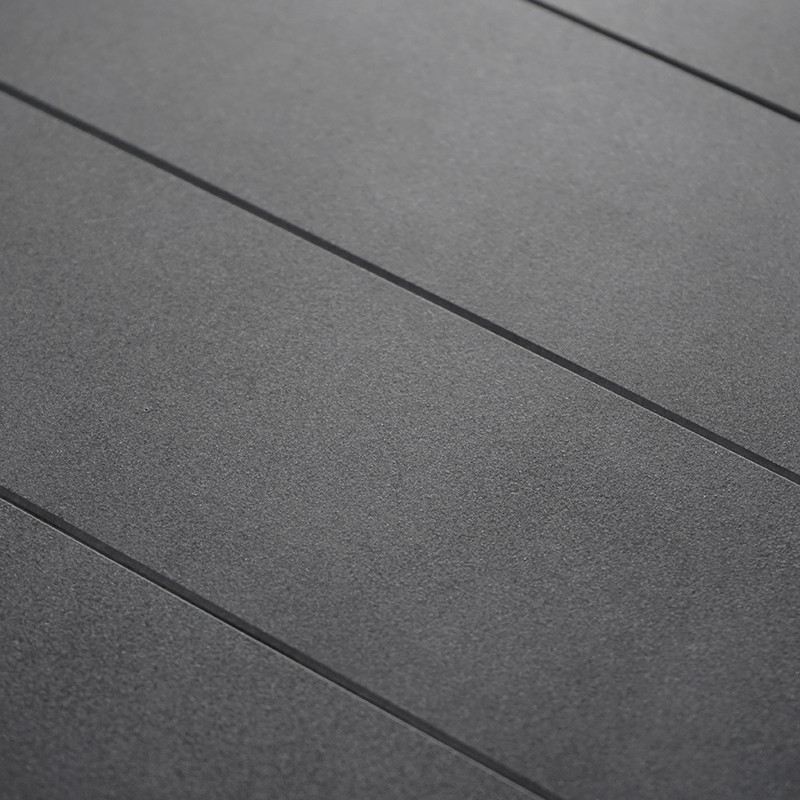 Gray floor tiles lie neatly in parallel rows, creating a uniform, textured surface in a minimalistic indoor space.