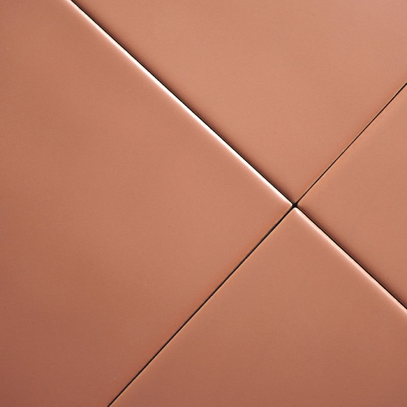 Quatre carreaux de couleur terre cuite disposés en diagonale, se croisant au centre, créant un motif géométrique homogène dans u