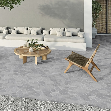 Azulejos de piedra gris forman el suelo y muestran un patrón geométrico debajo de una silla de madera y una mesa redonda en el e Azulejos de piedra gris forman el suelo y muestran un patrón geométrico debajo de una silla de madera y una mesa redonda en el e