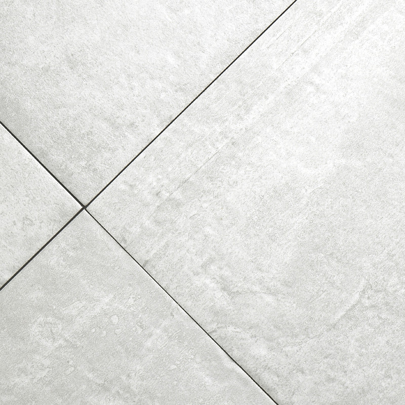 A smooth, light gray ceramic tile intersects with another, forming a diagonal grid pattern. Subtle textures suggest a natural st