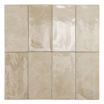 Een rechthoekige beige tegel met een gladde, glanzende afwerking ligt tegen een effen witte achtergrond.