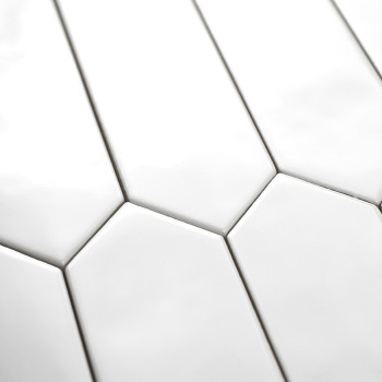 Witte langwerpige zeshoekige tegels zijn netjes gerangschikt in een verspringend patroon, waardoor een moderne, minimalistische 