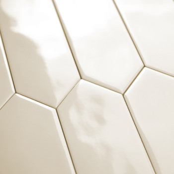 Les carreaux hexagonaux blancs, brillants et allongés sont alignés selon un motif décalé, réfléchissant la lumière, créant une s