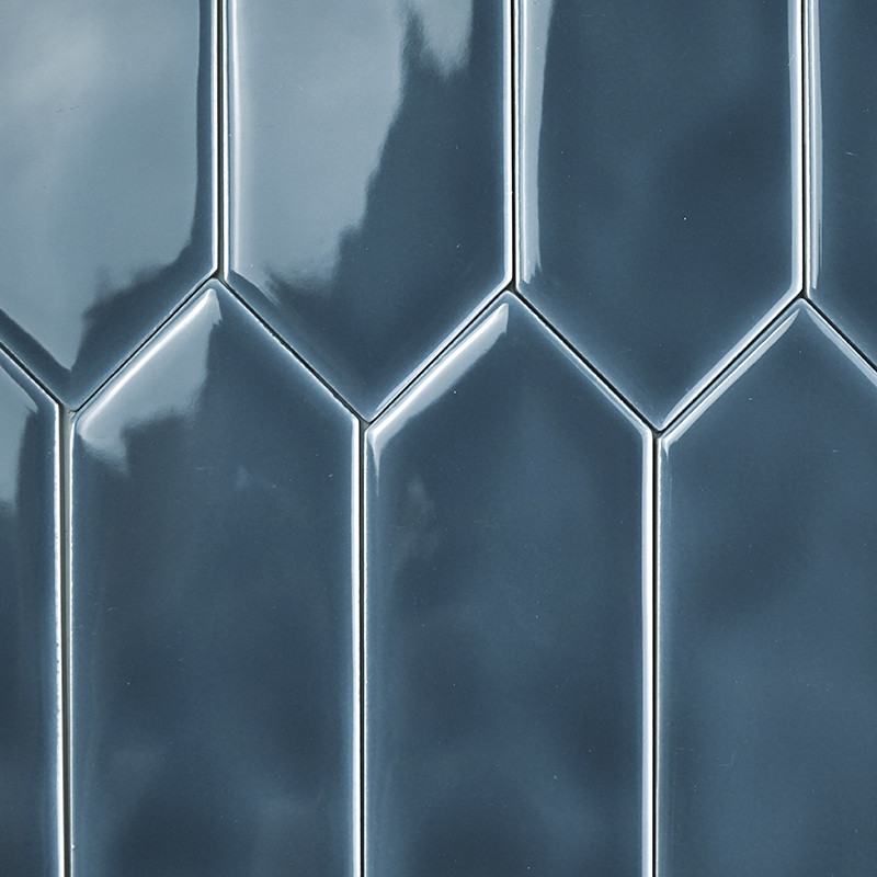 Glanzende, blauwe tegels die verticaal zijn gerangschikt, vormen een verspringend, geometrisch patroon. Het oppervlak reflecteer
