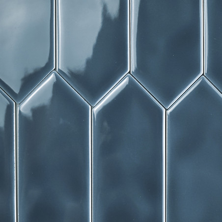 Glanzende, blauwe tegels die verticaal zijn gerangschikt, vormen een verspringend, geometrisch patroon. Het oppervlak reflecteer