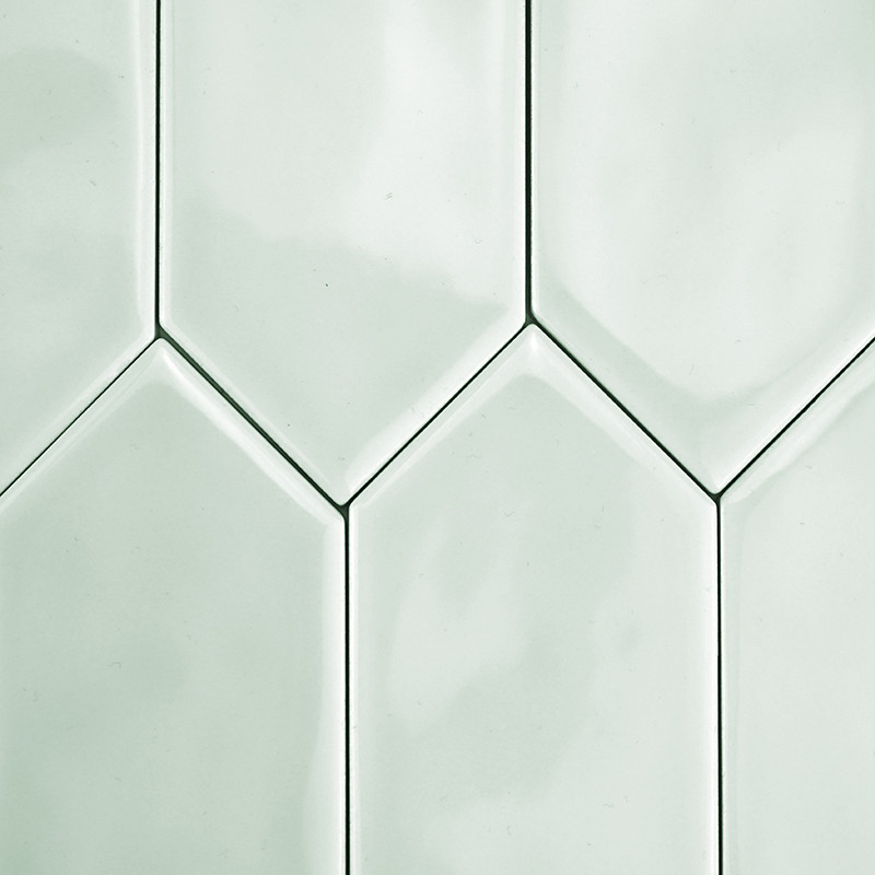 Les carreaux de céramique hexagonaux s'emboîtent en douceur, formant un motif continu aux teintes vert clair, reflétant une lumi