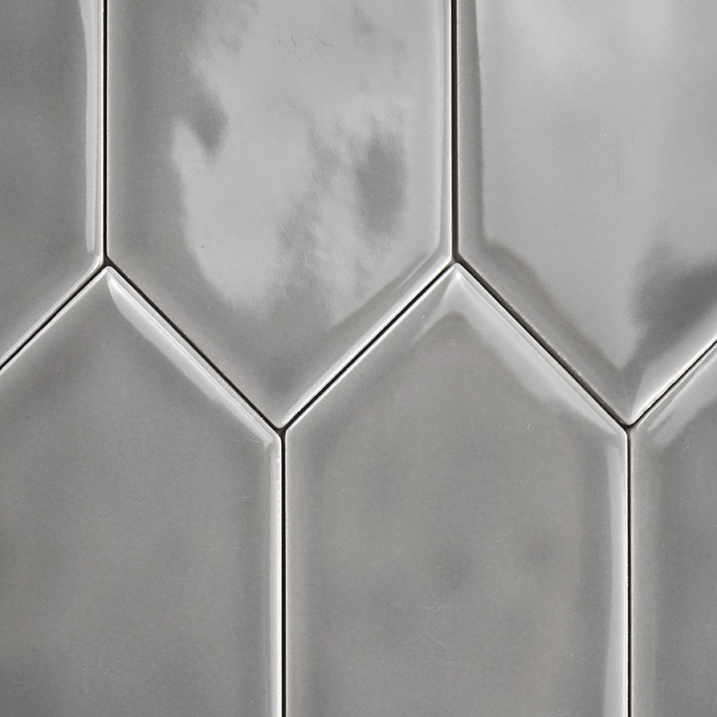 Glossy, gray, rectangular tiles interlock vertically. light reflections create a textured pattern, suggesting a modern bathroom 