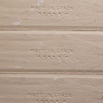 O texto em relevo `MADE IN SPAIN` aparece nas cumeeiras dos azulejos bege, com pequenos pontos abaixo de cada frase, destacando 
