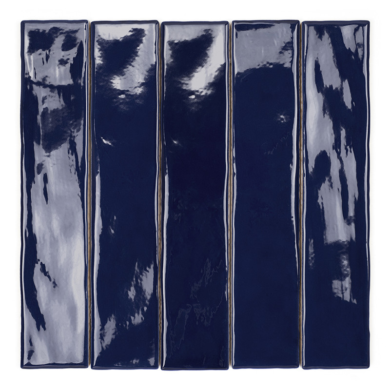 Um azulejo retangular longo, brilhante e azul profundo repousa sobre um fundo branco liso, exibindo padrões reflexivos sutis.