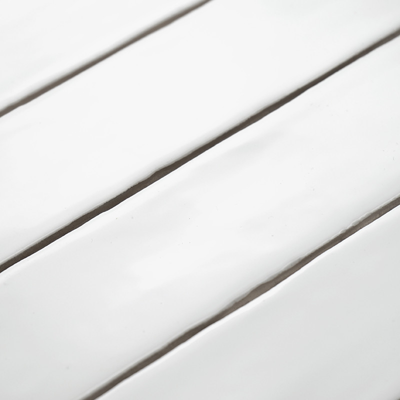 White ceramic tiles lie parallel, reflecting light, creating a glossy and sleek visual in a smooth, arranged setting.