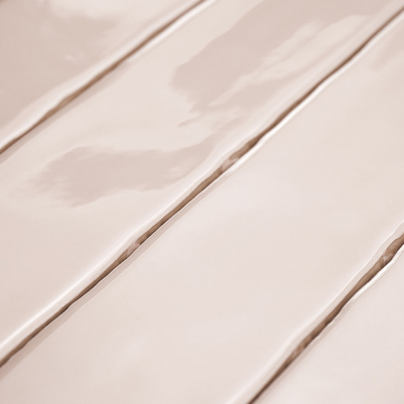 Beige, glossy ceramic tiles are laid out in parallel rows, reflecting light. The seamless, even surface suggests a clean, modern