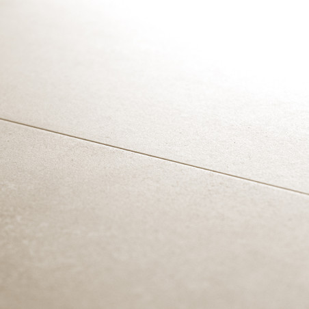 Un carreau beige et lisse croise un autre carreau, créant une fine ligne de coulis, sous un éclairage tamisé, suggérant un sol i