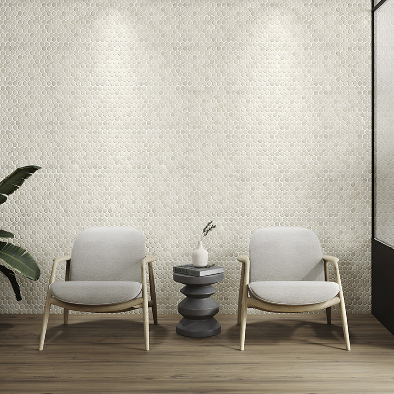 Elegantes Azulejos de piedra hexagonales forman una pared texturizada, iluminada por focos, detrás de dos sillas y una mesa.