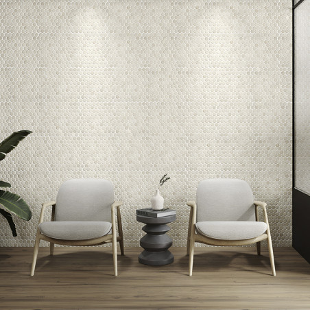 Elegante sechseckige Steinfliesen bilden eine strukturierte Wand, beleuchtet von Strahlern, hinter zwei Stühlen und einem Tisch.