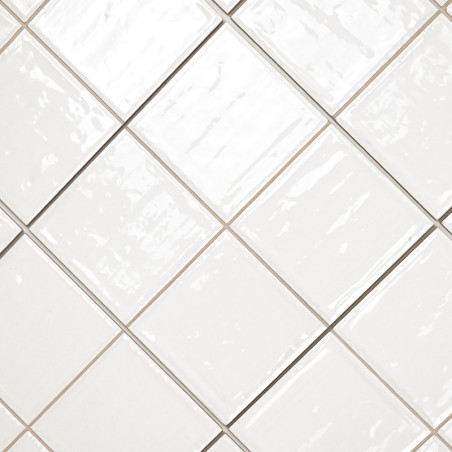 Witte keramische tegels diagonaal gerangschikt met een glanzende afwerking. de voegenlijnen vormen een contrasterend rasterpatro Witte keramische tegels diagonaal gerangschikt met een glanzende afwerking. de voegenlijnen vormen een contrasterend rasterpatro