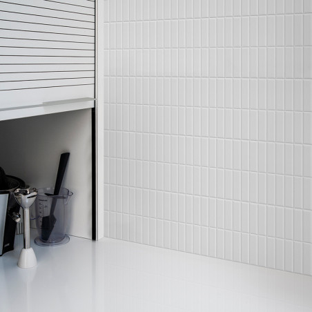 Los azulejos verticales blancos del metro cubren una pared y reflejan la luz en una cocina elegante y moderna con gabinetes y un Los azulejos verticales blancos del metro cubren una pared y reflejan la luz en una cocina elegante y moderna con gabinetes y un