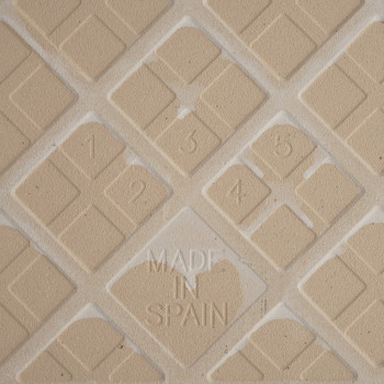 De lichtbruine getextureerde tegel toont een geometrisch ruitpatroon met de cijfers 1 tot en met 5 erin geëtst. In het midden zi