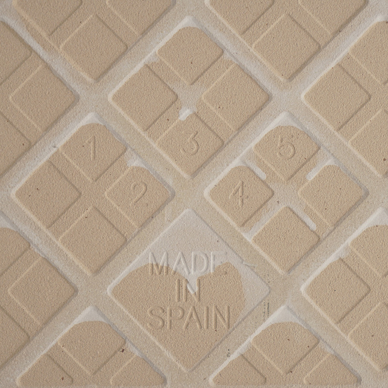 Kachel mit erhabenen Zahlen 1–6 in Rautenform. Der Text „MADE IN SPAIN“ ist zentral in das strukturierte Gittermuster eingebette