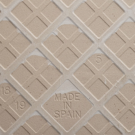 Um ladrilho bege apresenta um padrão de grade diagonal com pequenos quadrados recuados. `MADE IN SPAIN` e os números `18,` `19,` Um ladrilho bege apresenta um padrão de grade diagonal com pequenos quadrados recuados. `MADE IN SPAIN` e os números `18,` `19,`