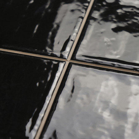 Glänzend schwarze Keramikfliesen reflektieren das Licht und sorgen für eine glatte Oberfläche. Die Fugenlinien bilden im Innenbe Glänzend schwarze Keramikfliesen reflektieren das Licht und sorgen für eine glatte Oberfläche. Die Fugenlinien bilden im Innenbe