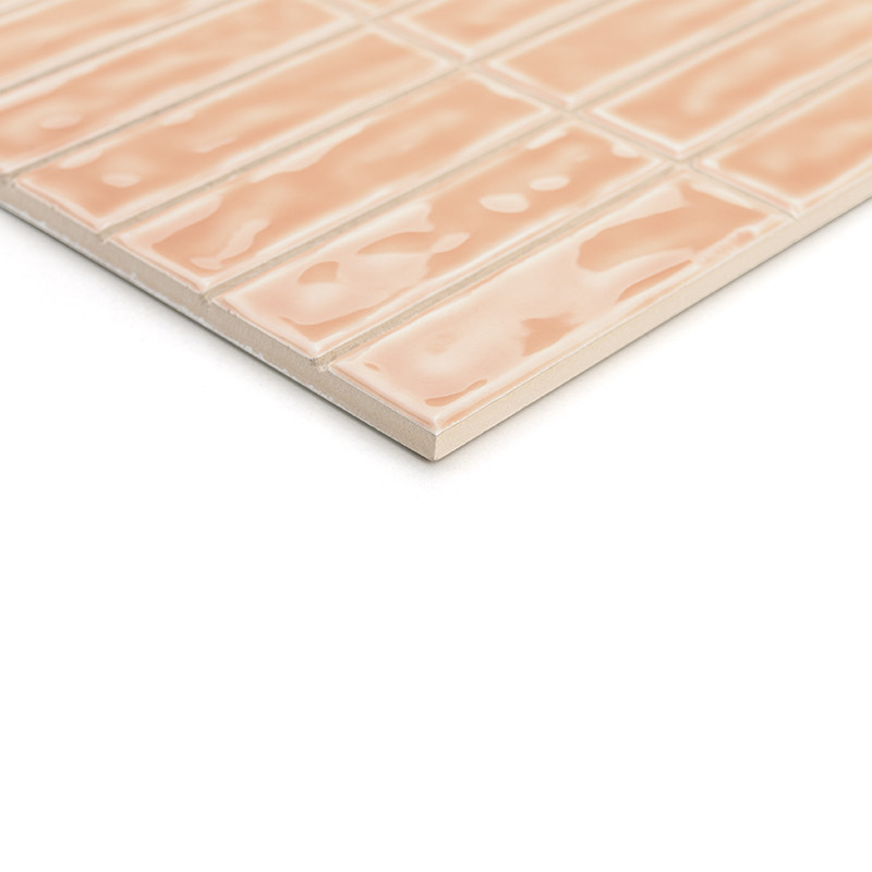 Un azulejo cerámico rectangular de color melocotón presenta un patrón de superficie ondulado y brillante. Está organizado en un 