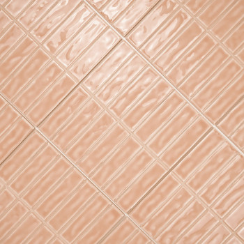 Rechthoekige perzikkleurige tegels zijn diagonaal gerangschikt, waardoor een golvend reflecterend patroon ontstaat over een vlak