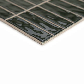 Ladrilhos verdes retangulares estão dispostos em fileiras organizadas em uma superfície lisa e brilhante, refletindo a luz em um