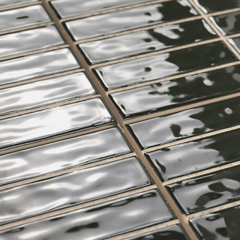 Rechteckige Fliesen, glänzend und dunkel, liegen in gleichmäßigen Reihen. Auf ihren glatten Oberflächen wird Licht reflektiert u