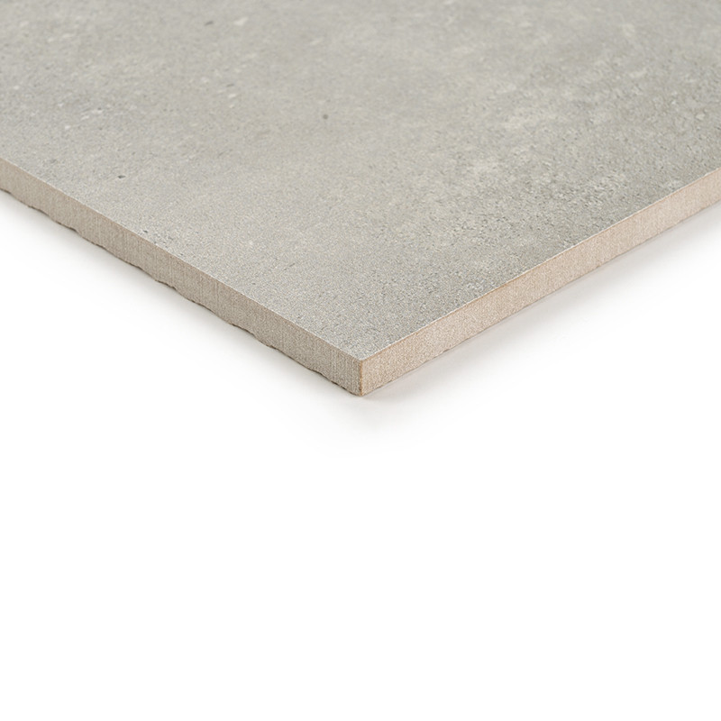 Un carreau de céramique carré et gris repose à plat, sa surface lisse réfléchissant la lumière. sur un fond blanc uni, soulignan