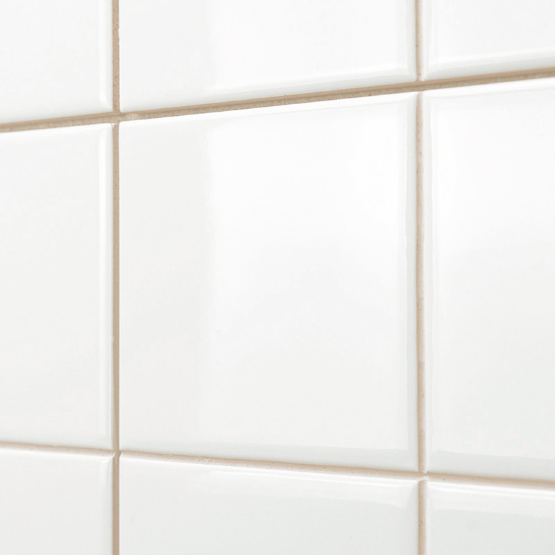 White, glossy ceramic tiles are arranged in a grid, creating a smooth, reflective surface. The tiles are set against a neutral b