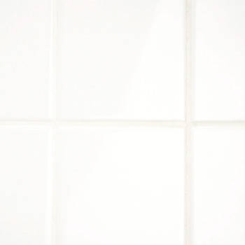 Les carreaux de céramique blanche sont disposés selon un motif en grille, créant une surface propre et lisse, faisant probableme