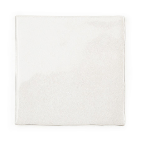 Un carreau carré blanc reste immobile et présente une surface lisse et légèrement texturée. Le fond uni souligne son design mini