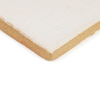Een vierkante, beige terracottategel ligt tegen een effen witte achtergrond en laat het gladde oppervlak en de ruwe randen zien.