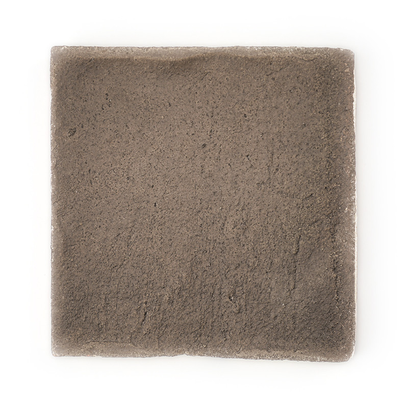 Carrelage carré en terre cuite. semble non émaillé, texture rugueuse. isolé sur un fond blanc uni, suggérant une présentation mi