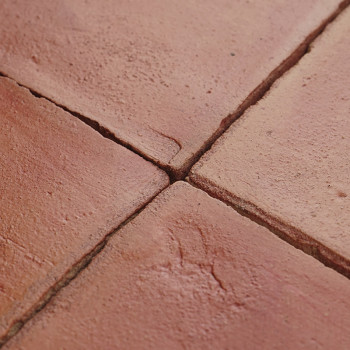 Terrakottafliesen laufen an einer Ecke zusammen und präsentieren Erdtöne und strukturierte Oberflächen, eingebettet in einen sau