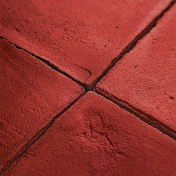 Les carreaux en terre cuite forment un motif en forme de grille, avec des coutures visibles, créant un aspect rustique et textur