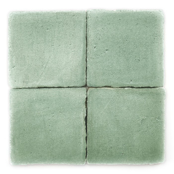 Cuatro Azulejos de terracota verde dispuestas en un cuadrado, mostrando una textura mate, con ligeros espacios que las dividen.