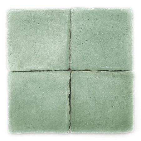 Cuatro Azulejos de terracota verde dispuestas en un cuadrado, mostrando una textura mate, con ligeros espacios que las dividen.